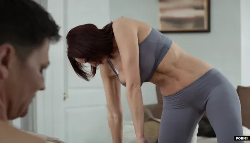A warm-lit living room frames a flabby mother in her early thirties