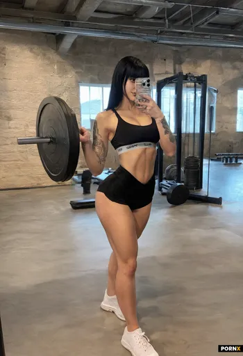 A full-body photograph of a muscular and fit 18 year old woman with long dark hair and bangs