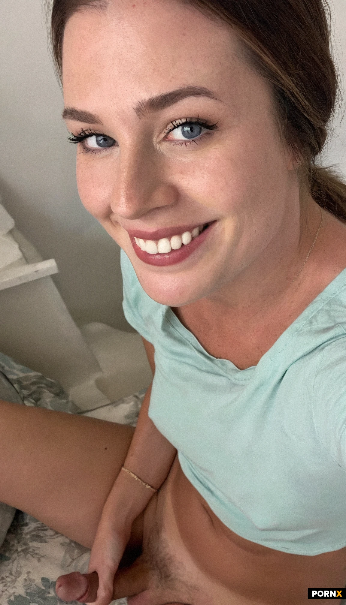 Close up view of One (cute) American woman sitting relaxing,30 years old,smiling,t-shirt,panties,nude,brunette hair,blue eyes,small breasts,bedroom,looking at viewer,simple ponytail,simple background,(close up view),flaccid penis,<lora:054:0.5>,view from above,cute face,solo