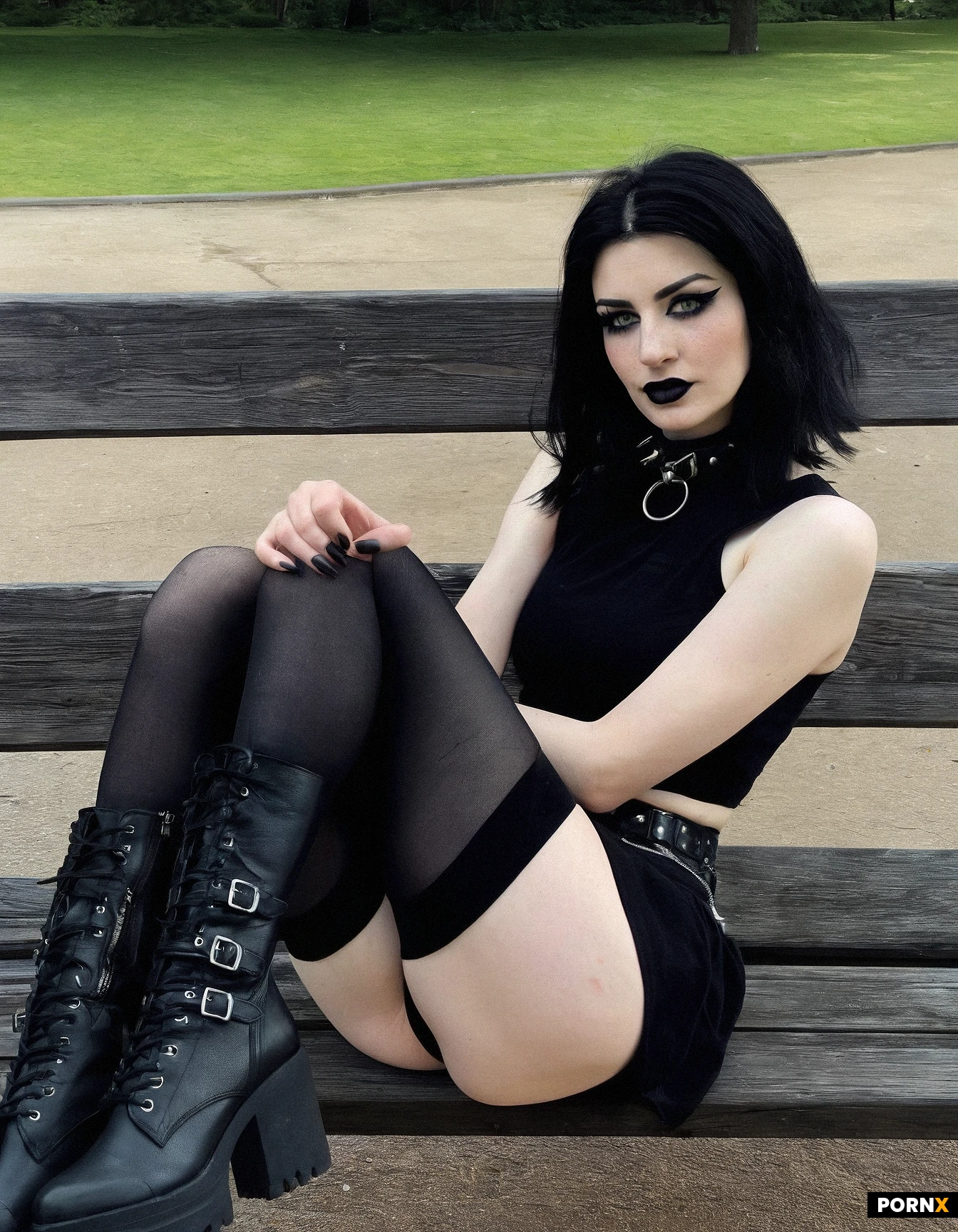 goth girl with messy medium length black hair. 22 years old. spiked dog collar. pale skin. black eye liner, black lipstick. green eyes. sitting on a park bench. hands in lap. black band tee shirt off one shoulder, black skirt, white stockings, black biker boots. sexy facial expression. looking at the camera. black nail polish. (short fingernails). black garter belt. light freckles on her nose. (smudged mascara)