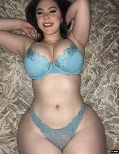 A confident 18 year old woman with a round youthful slightly chubby face; her massive tits are spill