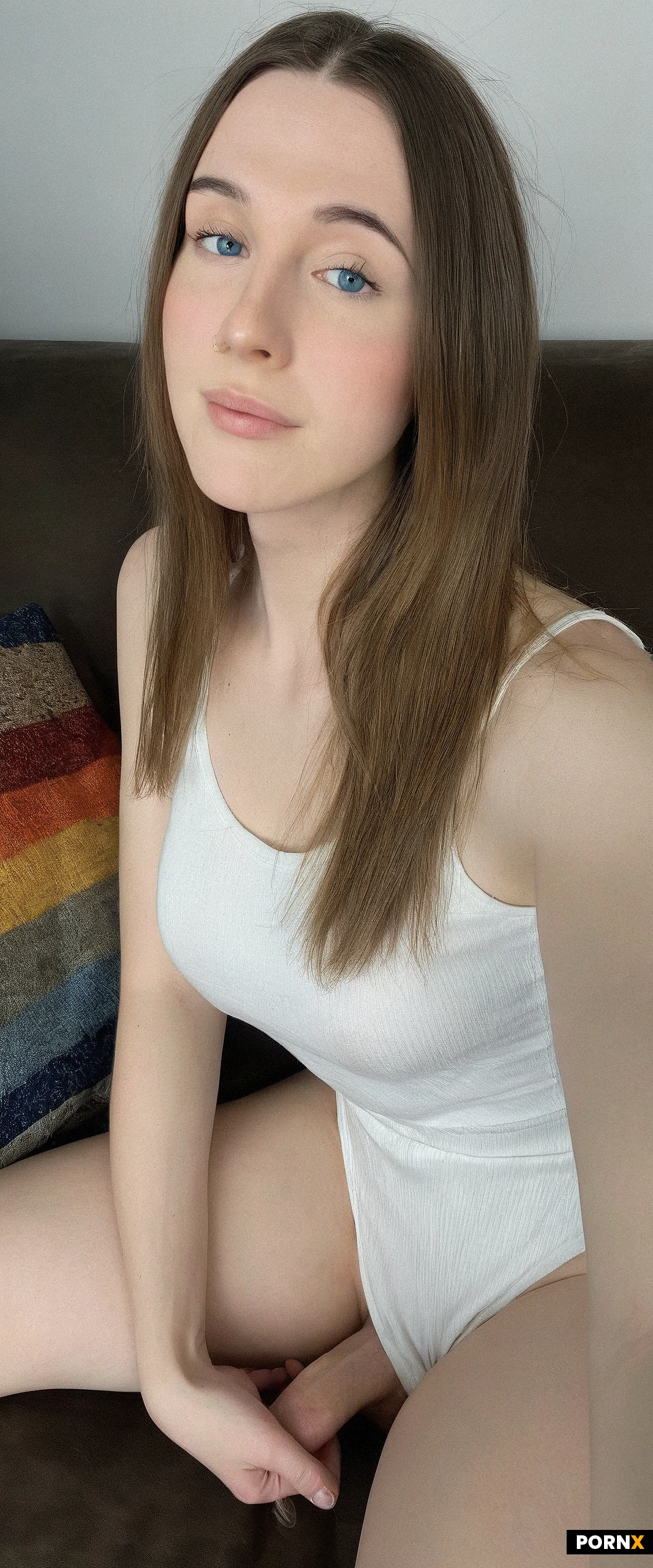 photorealistic,candid,one cute American futanari woman sitting on couch,looking at viewer,18 years old,(soft body),(cute face),blue eyes,round face,white tanktop,(small panties),(bulge),living room,straight hair,brunette hair,no makeup,simple background,side view,close up view